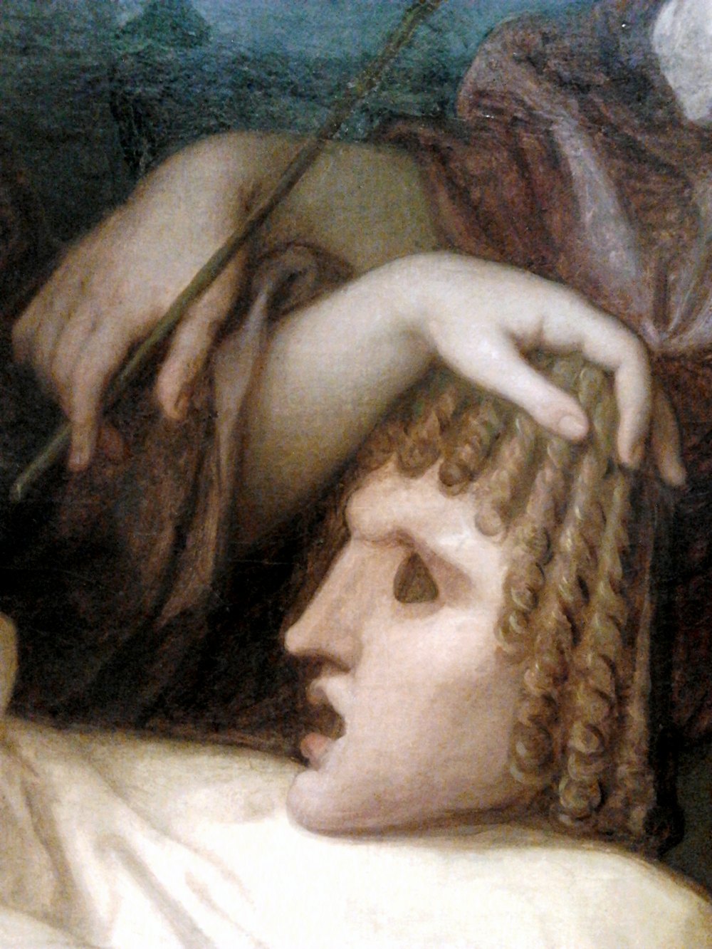 A hand resting on a classical theatrical mask