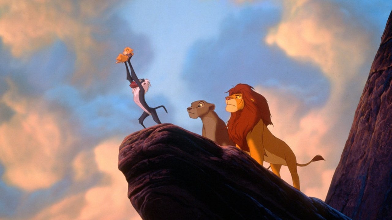 Rafiki holding the new cub aloft on Pride Rock. Mufasa and Sarabi watch. The cycle begins again.